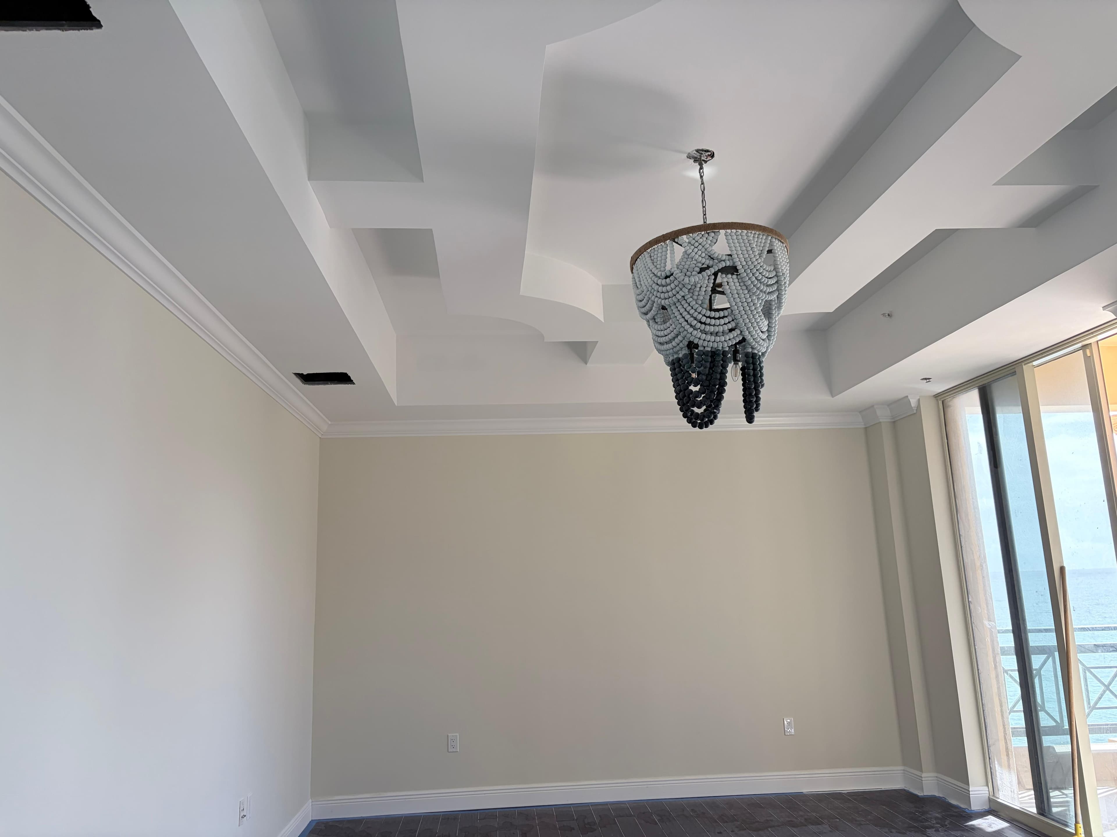 Living room with coffered ceiling and ocean view — premium renovation